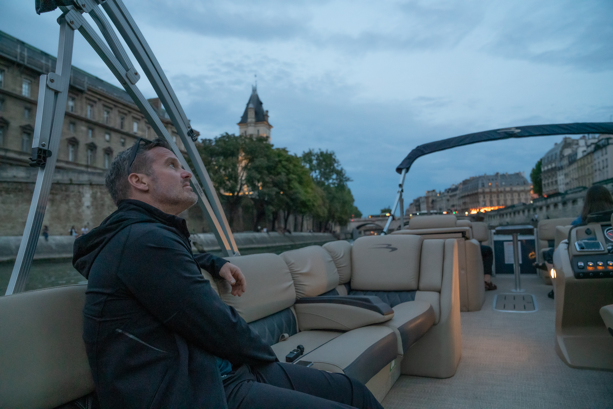 Man sitting in a private boat at dusk on the Seine river in Paris, France